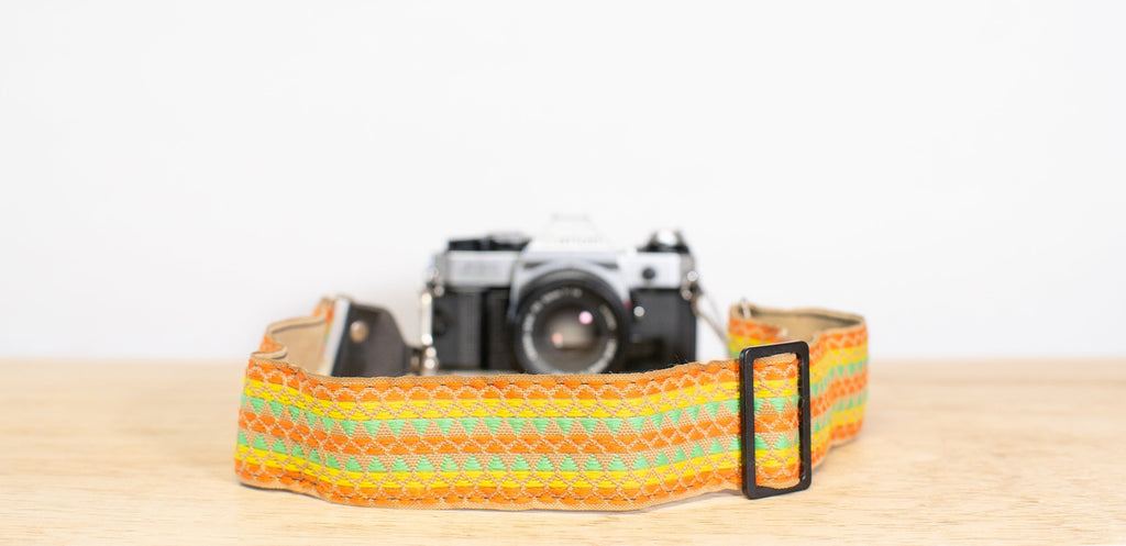 camera strap in neon shades of green, orange, and yellow.